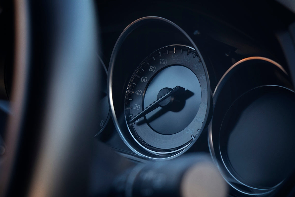 A close up of a car dashboard with a speedometer