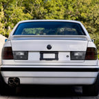 Euro smoke tail lights installed on a white BMW E34 sedan