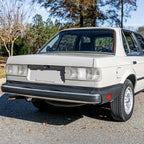 All clear tail lights installed on a white BMW E30 sedan