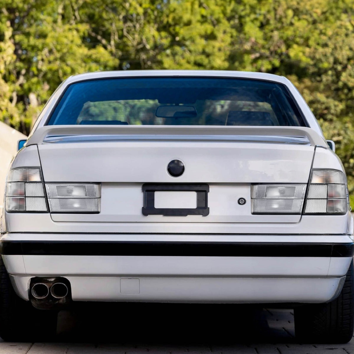All clear tail lights installed on a white BMW E34 sedan