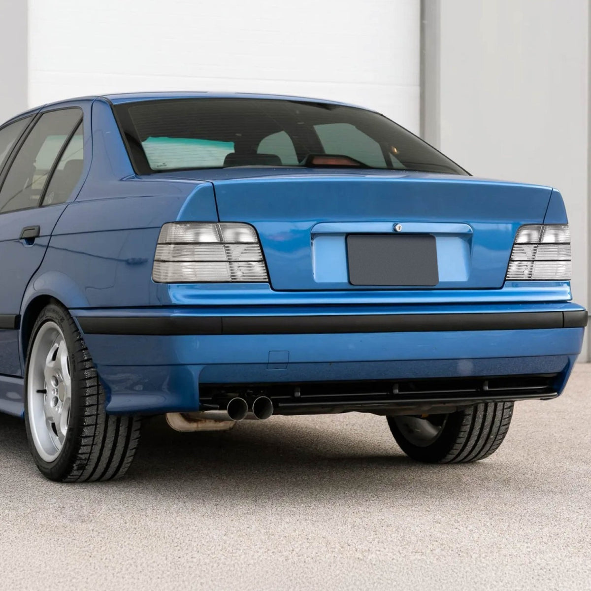 All clear tail lights installed on a blue BMW E36 sedan