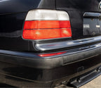 Euro style red/clear tail light installed on a black BMW E36 sedan
