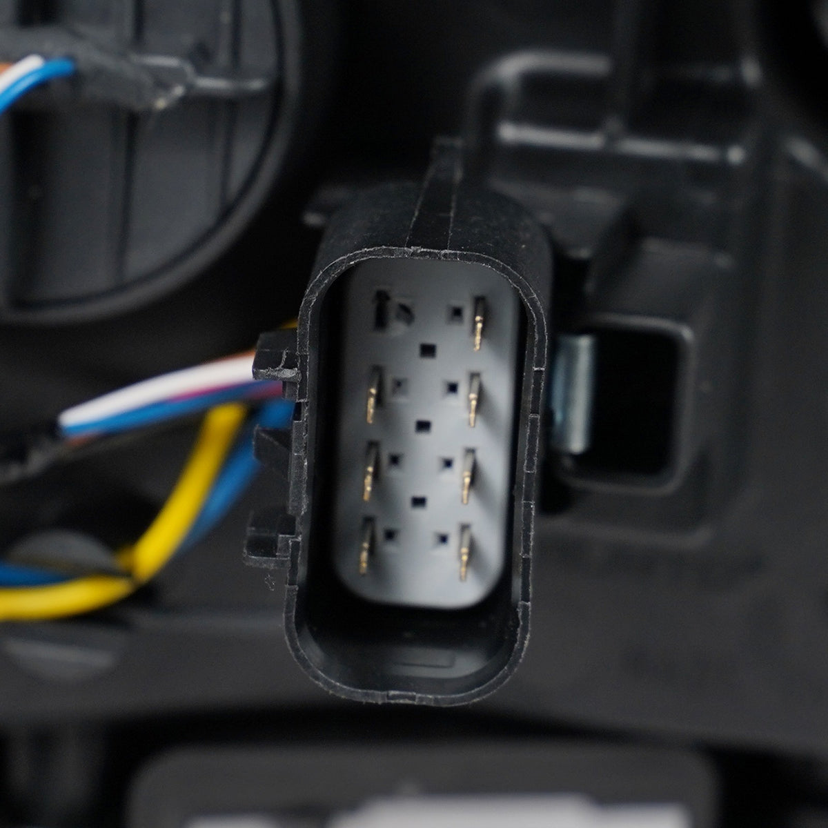 Halogen projector headlight mounting tab close-up for 2015-2019 GMC Sierra HD