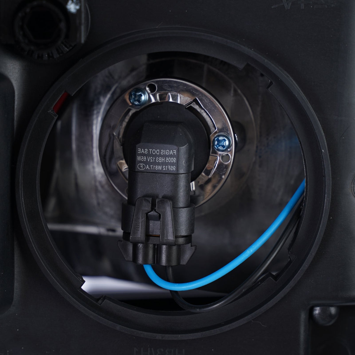 Halogen projector headlight mounting tab close-up for 2015-2022 GMC Canyon
